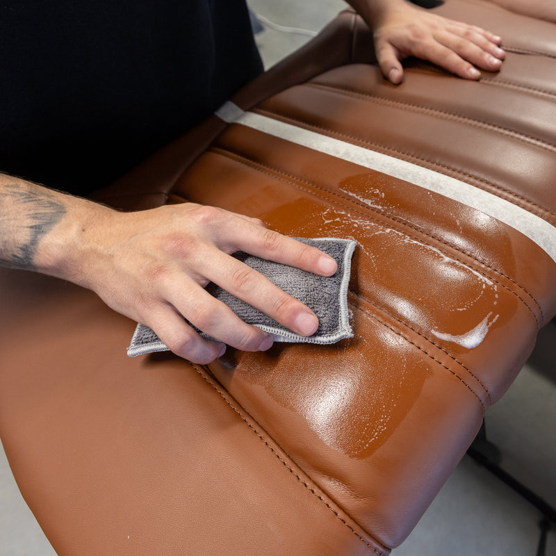 Limpieza de un asiento de cuero marrón con un Scrub Pad.
