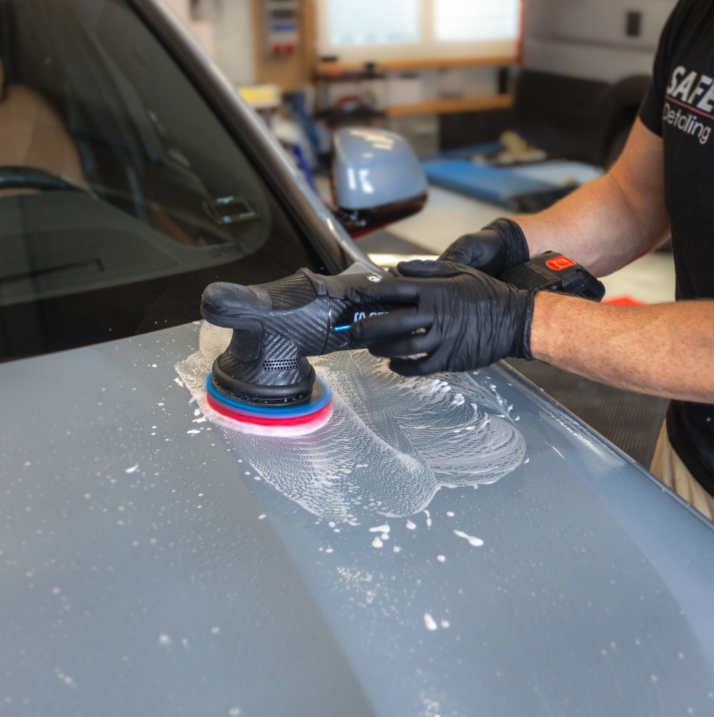 Clay-Disk auf einer Exzenter-Poliermaschine bei der Reinigung einer benetzten Motorhaube